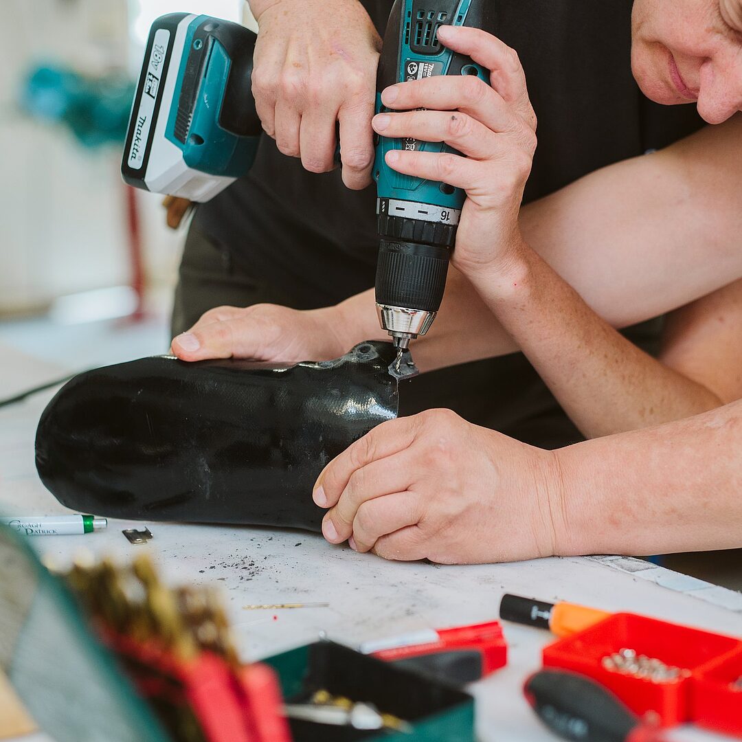 Orthopädietechniker bohrt an einer Unterschenkelorthese