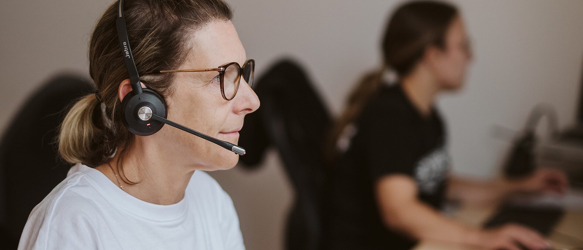 Zwei Mitarbeiterinnen des ORFO-Innendiensts mit Headset am Arbeitsplatz
